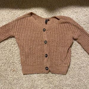 Adorable knitted cropped cardigan with buttons down the middle.